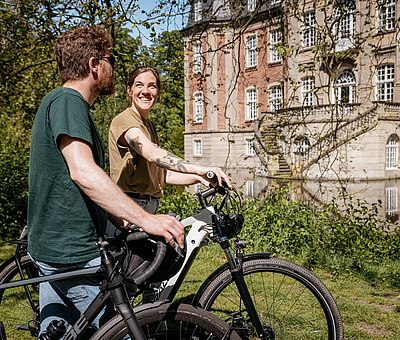 Zwei Personen schauen auf Schloss Loburg in Ostbevern 